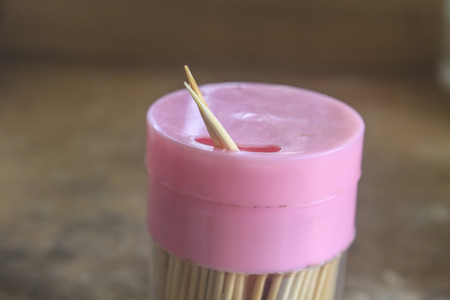 toothpicks in the glass cup with wooden backgroundの写真素材