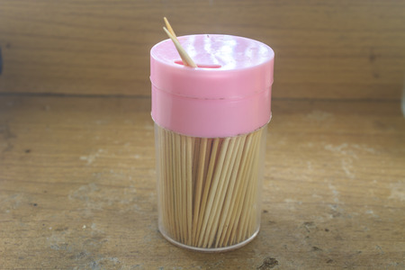 toothpicks in the glass cup with wooden backgroundの写真素材