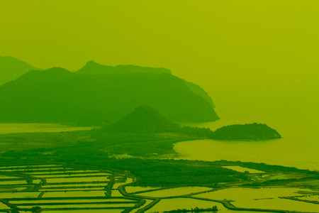 Shrimp farms and limestone mountains in countryの写真素材