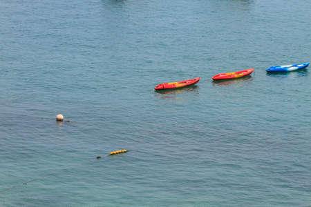 Colourful kayaks floating on tropical seaの写真素材