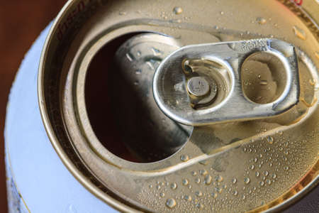 Closeup shot from the pull ring on a beverage can, opened aluminum can with water drop