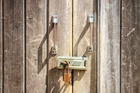 Padlock on wooden background, pad lock secures an old doorの写真素材
