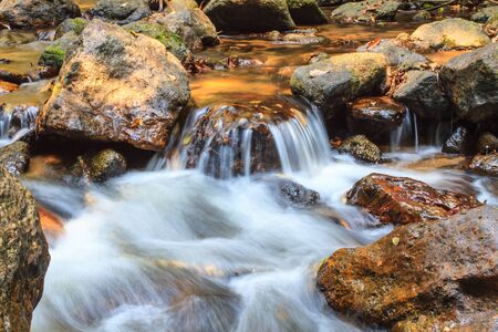 rainforest waterfall and rocks covered with moss in streamの写真素材