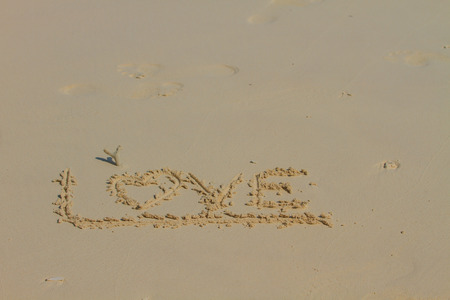 Word LOVE on sand, Drawing love word on beachの写真素材