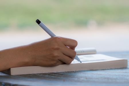 Young girl writes on a book, education or business conceptの写真素材