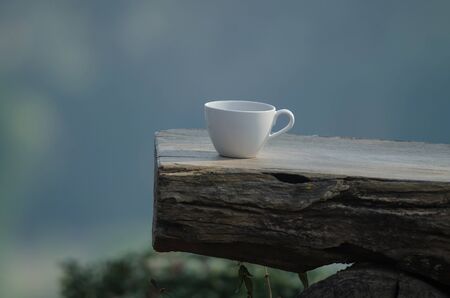hot coffee on the old log with nature backgroundの写真素材