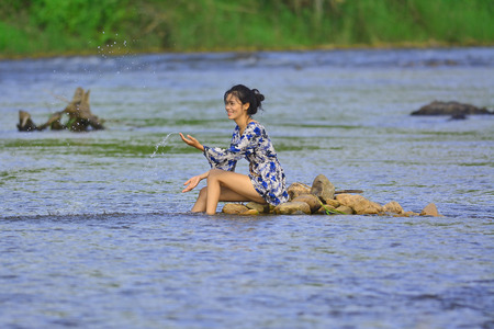 Portrait of young girl in river, Young girl posing on the waterの写真素材