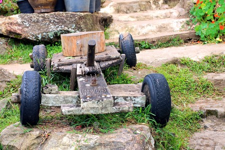 Old wooden rustic toy car on a garden backgroundの写真素材