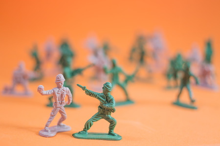 Closeup of action mini toy soldier on orange backgroundの写真素材