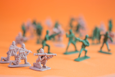 Closeup of action mini toy soldier on orange backgroundの写真素材