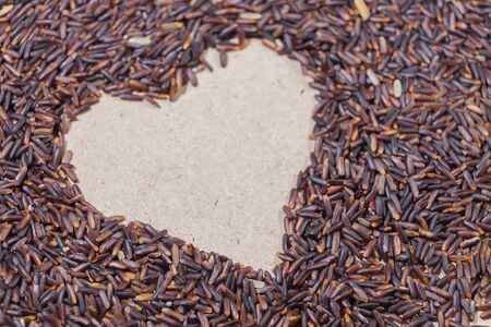 Close-up heart shape brown rice on wooden backgroundの写真素材