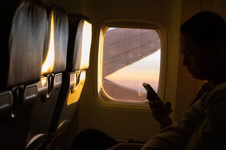 CHIANG MAI ,THAILAND - APRIL 27 ,2015 : Undefined traveler holding smart phone in the airplanes while flying, on April 27, 2015 in Chiangmai,Thailand.のeditorial素材