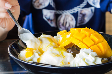 Vanilla Ice Cream With Fresh Mangoes on Black plateの写真素材