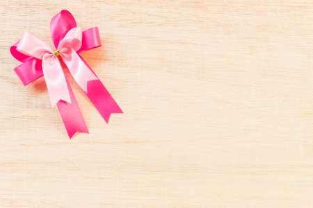 Pink ribbon bow on wooden backgroundの写真素材