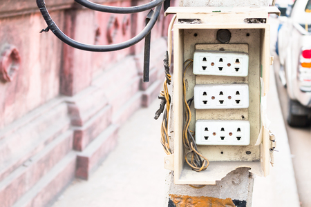 Wall plug on power pole on the side of the road.の写真素材