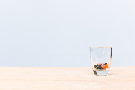 Pill in glass on wooden floor and concrete backgroundの写真素材