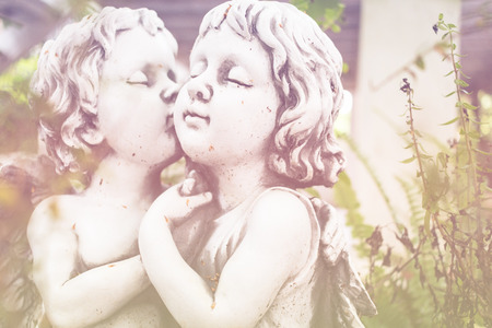 Angel Cupid ,White plaster figurine in the gardenの写真素材