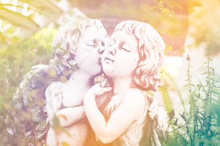 Angel Cupid ,White plaster figurine in the gardenの写真素材