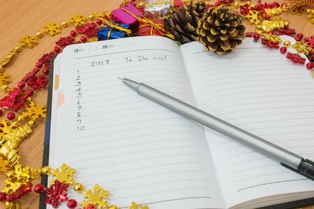 Notebook on a wooden table with new year goals 2017の写真素材