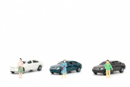 Miniature figures of women and car on white backgroundの写真素材