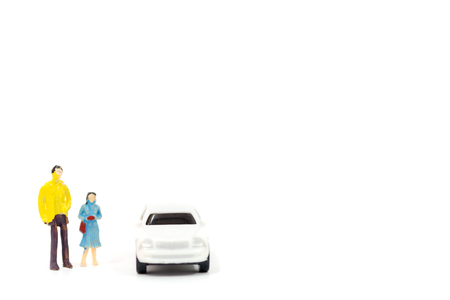 Miniature figures of people and car on white backgroundの写真素材