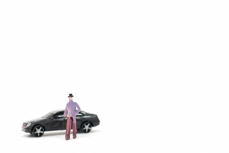 Miniature figures of man and car on white backgroundの写真素材