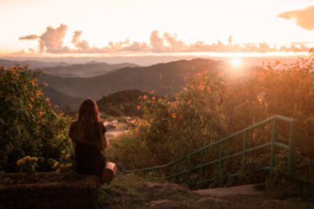 Blurred image , Lonely woman sitting  and watching the sunsetの写真素材