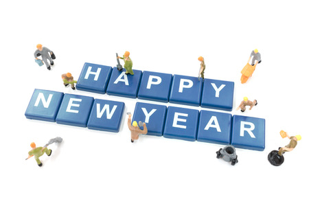 Miniature worker team building word happy new year on white backgroundの写真素材