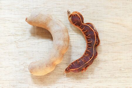 Sweet ripe tamarind pods on wood backgroundの写真素材