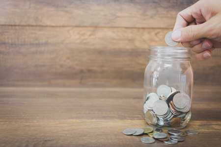 Money in the glass on wooden background