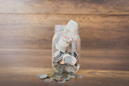Money in the glass on wooden background