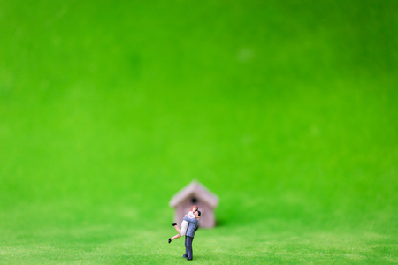Miniature bamboo house and couple on green yardの写真素材
