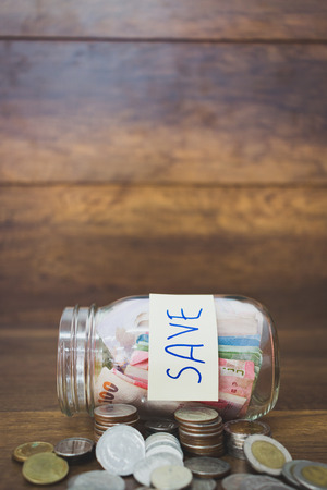 Money in the glass on wooden backgroundの写真素材