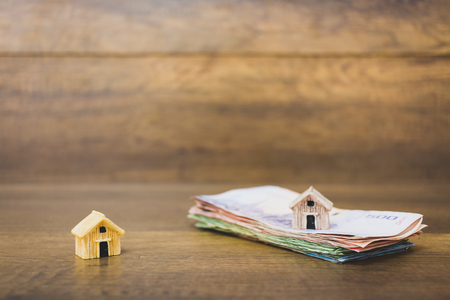House model and money on wooden background , Finance and banking concept.の写真素材
