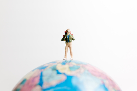 Miniature people figure  standing on the globe world map with white background and copy space as travel conceptの写真素材