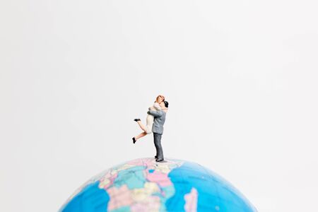 Miniature people figure  standing on the globe world map with white background and copy space as travel conceptの写真素材