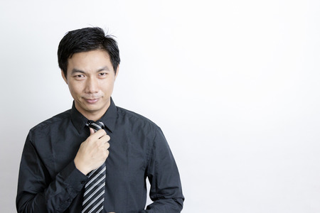 Portrait of Asian businessman standing on grey backgroundの写真素材