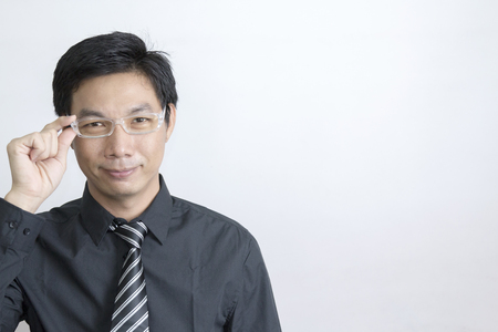 Portrait of Asian businessman standing on grey backgroundの写真素材