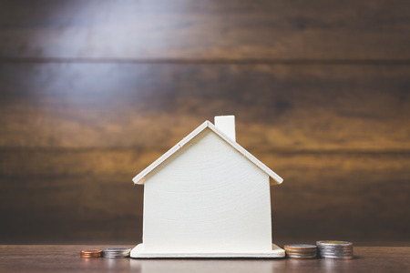 House models with stack coins on wooden table , Business asset concept
