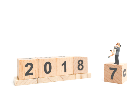 Miniature couple hugging on wooden block number 2018 with a space for text