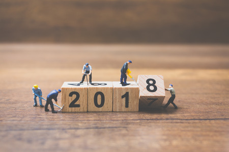 Miniature worker team building wooden block number 2018 on wooden backgroundの写真素材