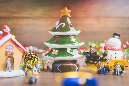 Creative concept with miniature people creating Christmas decorations on a wooden background. , Concept of teamwork.の写真素材