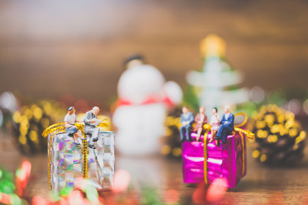 Miniature people on gift box with Christmas Day celebration backgroundの写真素材