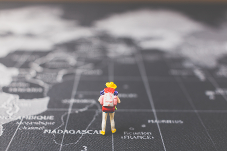Miniature people backpacker walking on world map, Tourism and travel concept