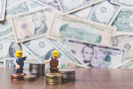 CHIANG MAI , THAILAND - September 23 , 2017 Miniature Business people with US dollar banknote backgroundのeditorial素材