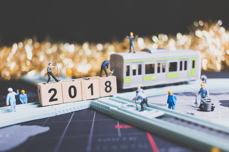 Miniature people worker build wooden block number 2018 on rail way