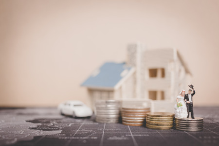 Miniature people bride and groom with coins money at home , Success family conceptual.の写真素材