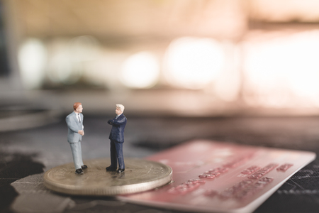 Miniature people businessman standing on coin , Business and finance conceptの写真素材