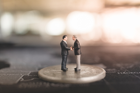 Miniature people businessman standing on coin , Business and finance conceptの写真素材