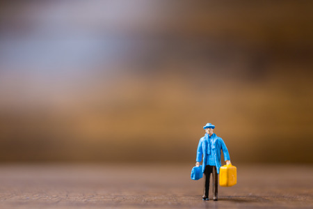 Miniature people travelers standing on wooden background , Travel conceptの写真素材